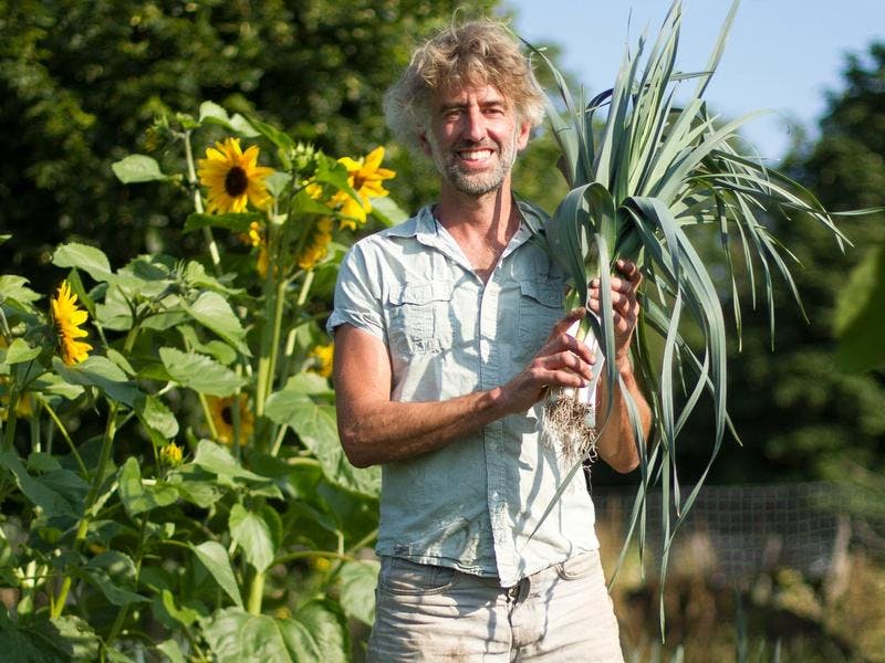 Tuinder Dave met prei en zonnebloemen